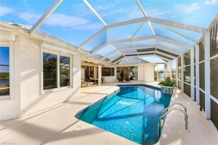Swimming pool with a lanai, a sunroom, and a patio area