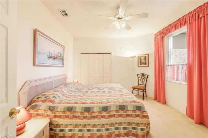 Carpeted bedroom featuring a ceiling fan and a closet