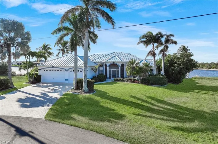View of front facade with driveway, a front lawn, a garage, and stucco siding