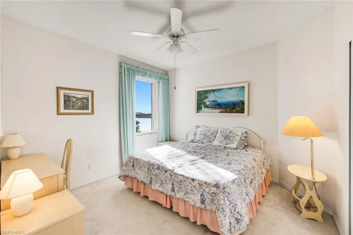 Carpeted bedroom featuring ceiling fan and baseboards