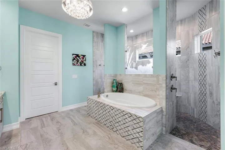 Bathroom featuring walk in shower, a bathtub, vanity, recessed lighting, and custom tile flooring