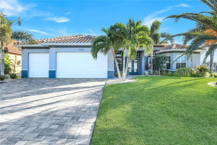 Mediterranean / spanish home featuring a front lawn, decorative paver driveway, stucco siding, an attached garage, and a concrete tile roof