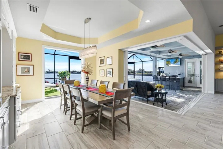 Dining room with a view of Lavedo Lake, tray ceiling, and custom light fixture