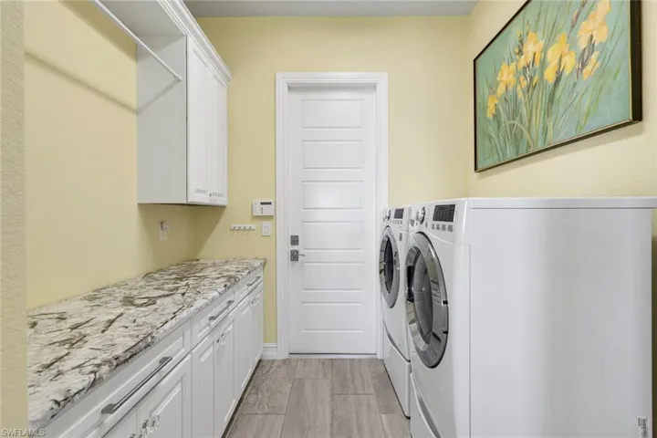 Laundry room with front loading washer and dryer and cabinet space