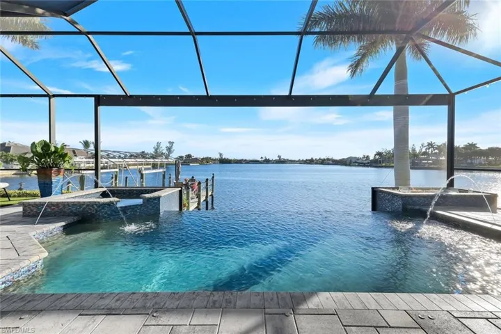 Dock featuring a lanai, a pool with connected hot tub, a water view, and boat lift