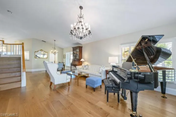 Airy Great room featuring wood floors and volume ceiling