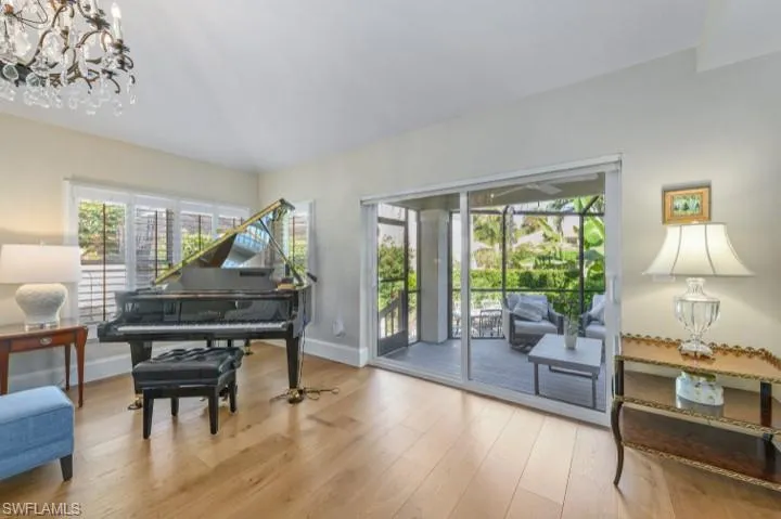 Living area featuring new hurricane impact sliders, wood finished floors, natural light, plantation shutters throughout