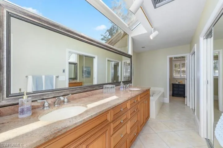 Ensuite Primary Bathroom featuring newly installed hurricane impact atrium windows and double vanity