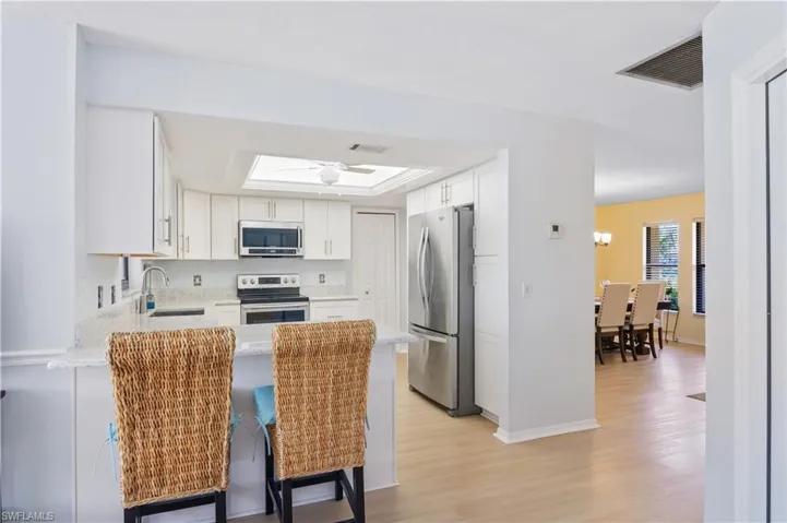 Kitchen featuring visible vents, a sink, appliances with stainless steel finishes, and a peninsula