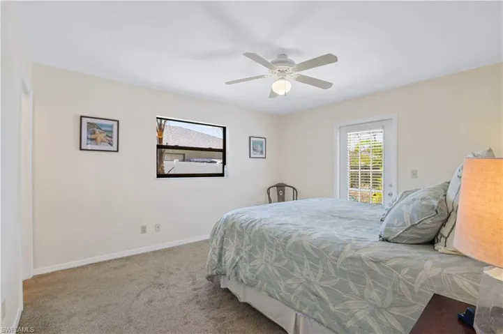 Carpeted bedroom featuring baseboards and a ceiling fan