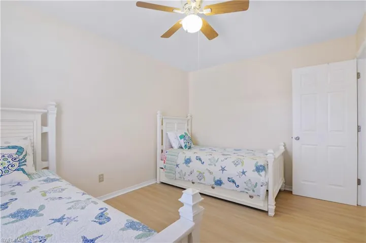 Bedroom with ceiling fan, baseboards, and light wood-type flooring