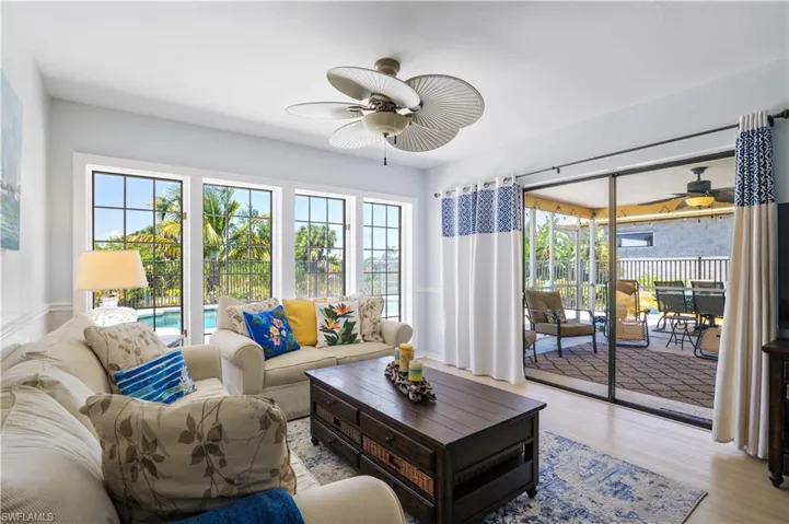 Living area with plenty of natural light, light wood-style floors, and ceiling fan