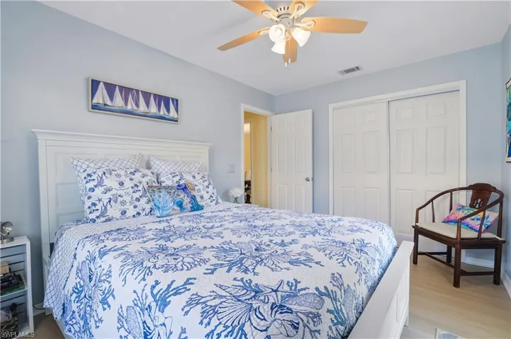 Bedroom with a ceiling fan, a closet, wood finished floors, and visible vents