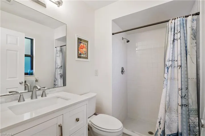 Bathroom featuring toilet, visible vents, a shower stall, and vanity