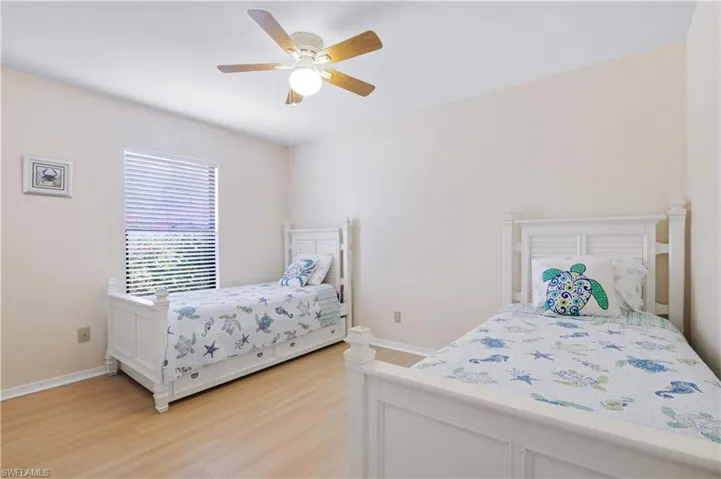 Bedroom featuring baseboards, a ceiling fan, and light wood-type flooring
