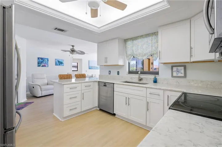 Kitchen featuring visible vents, a ceiling fan, a sink, and stainless steel appliances