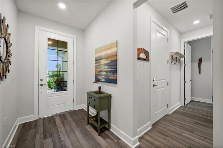 Entryway with dark wood-type flooring and recessed lighting