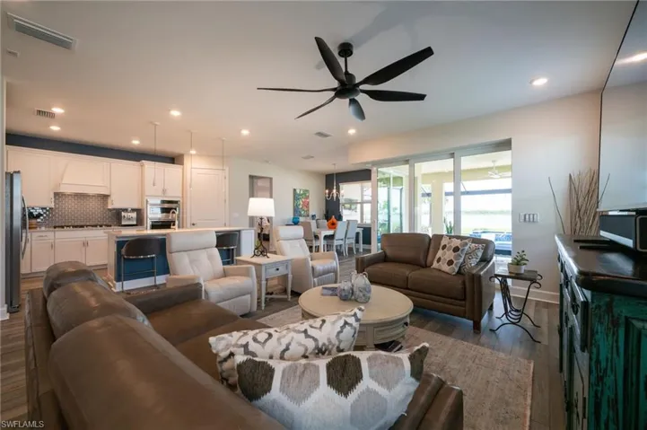 Living room featuring a ceiling fan, wood finished floors, and recessed lighting