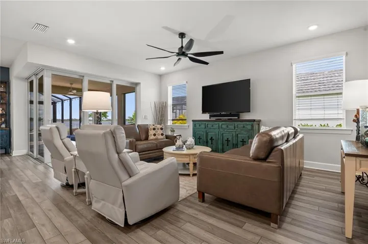 Living area featuring ceiling fan, light wood-style floors, healthy amount of natural light, and recessed lighting