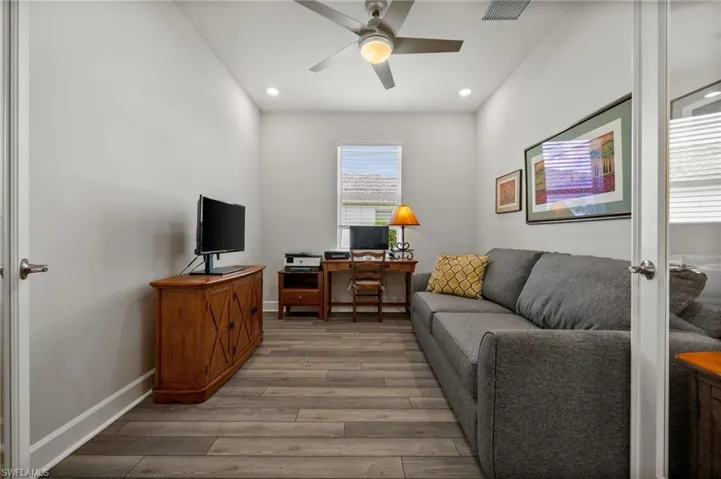 Living room featuring light wood-style flooring, ceiling fan, recessed lighting, and an office area