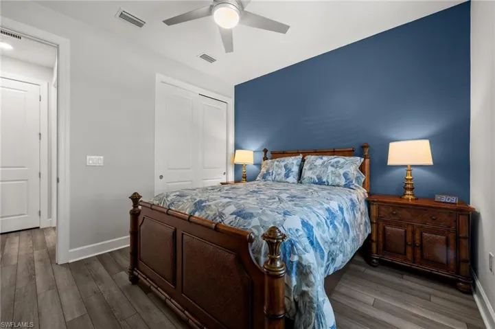 Bedroom with wood finished floors, a closet, and ceiling fan