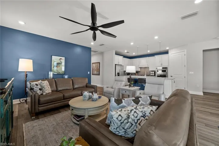 Living room featuring wood finished floors, ceiling fan, and recessed lighting