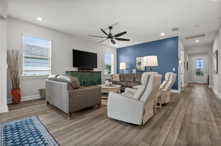 Living room featuring wood finished floors, a ceiling fan, and recessed lighting