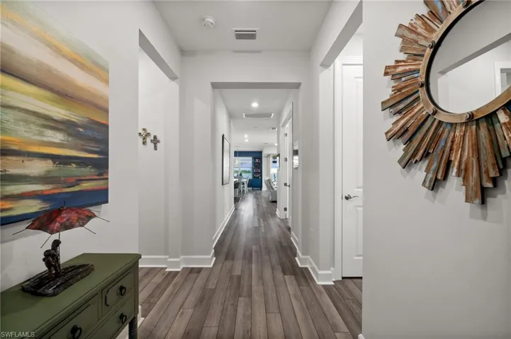 Corridor with dark wood-type flooring and recessed lighting