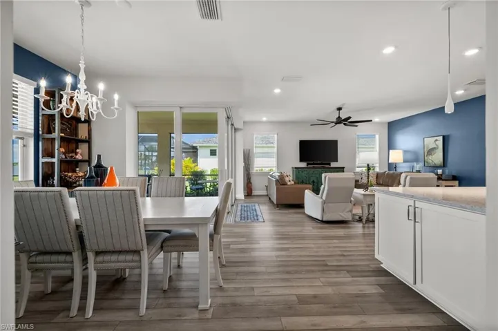 Dining space featuring a chandelier, wood finished floors, ceiling fan, and recessed lighting
