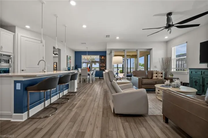 Living area with ceiling fan, wood finished floors, recessed lighting, and a chandelier