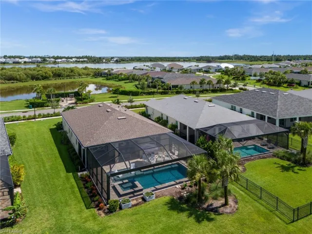 Aerial perspective of suburban area featuring a pool area and a large body of water