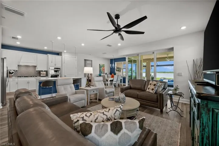 Living room with a ceiling fan, wood finished floors, and recessed lighting