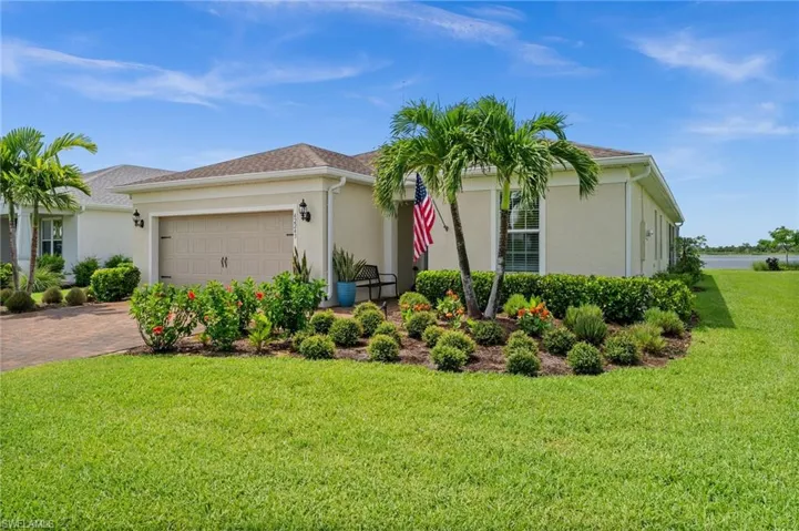 View of front of property with stucco siding, a front lawn, an attached garage, and decorative driveway