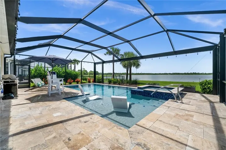 View of pool with a water view, a patio area, area for grilling, and a pool with connected hot tub