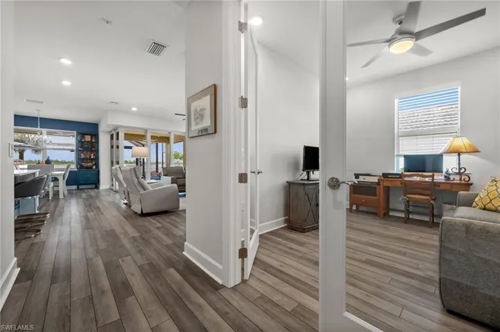 Office space with wood finished floors, ceiling fan, recessed lighting, and a chandelier