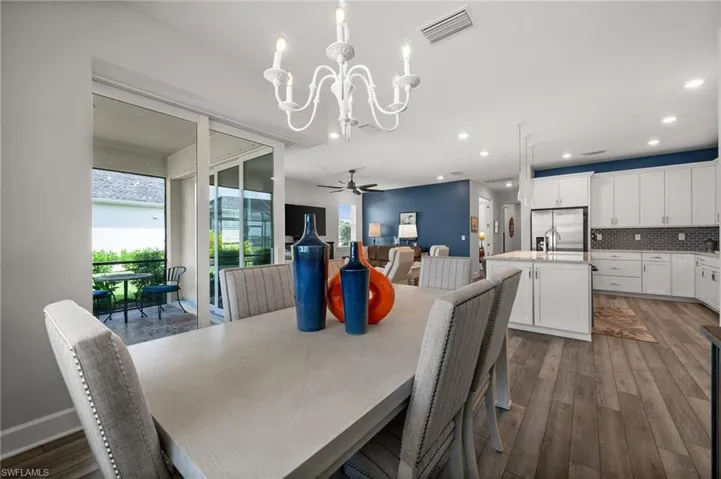 Dining area with a chandelier, dark wood-type flooring, recessed lighting, and ceiling fan