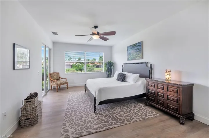 Bedroom with access to exterior, light wood-style floors, and a ceiling fan