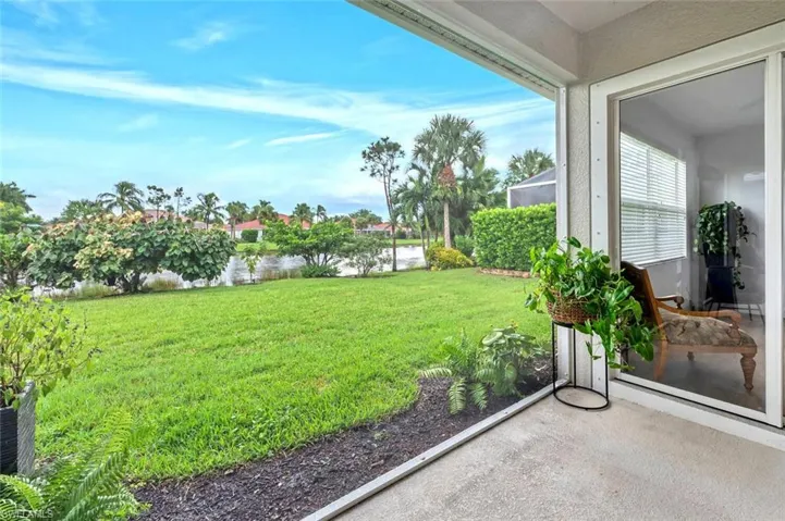 View of grassy yard with a water view and a sunroom