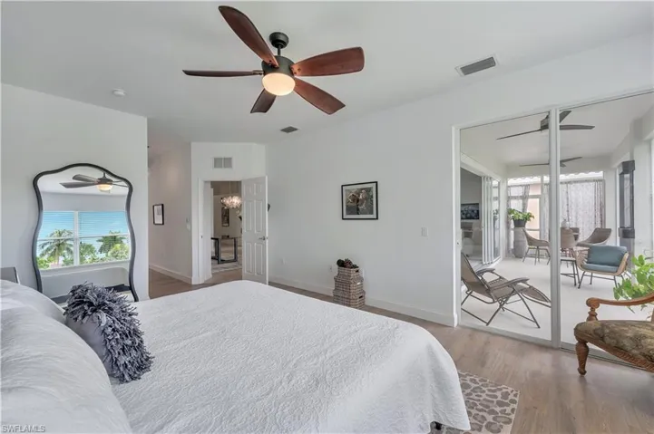 Bedroom with wood finished floors, ceiling fan, and access to exterior
