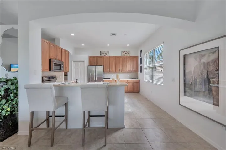 Kitchen featuring a breakfast bar, tasteful backsplash, appliances with stainless steel finishes, recessed lighting, and a peninsula