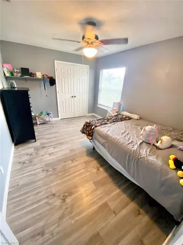 Bedroom featuring ceiling fan, light hardwood / wood-style floors, and a closet