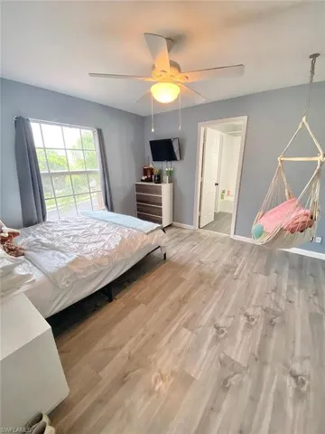 Bedroom featuring ensuite bath, ceiling fan, and light hardwood / wood-style flooring