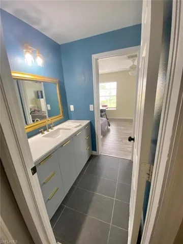 Bathroom with vanity, ceiling fan, and tile patterned floors