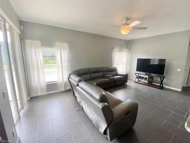 Living room featuring tile patterned floors and ceiling fan