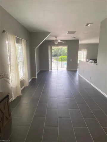 Tiled spare room with ceiling fan