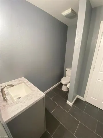 Bathroom featuring vanity, tile patterned flooring, and toilet