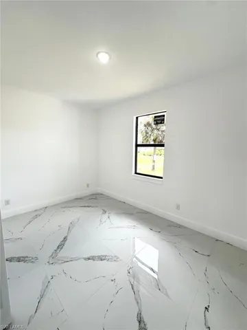 Empty room with baseboards and light marble finish floors