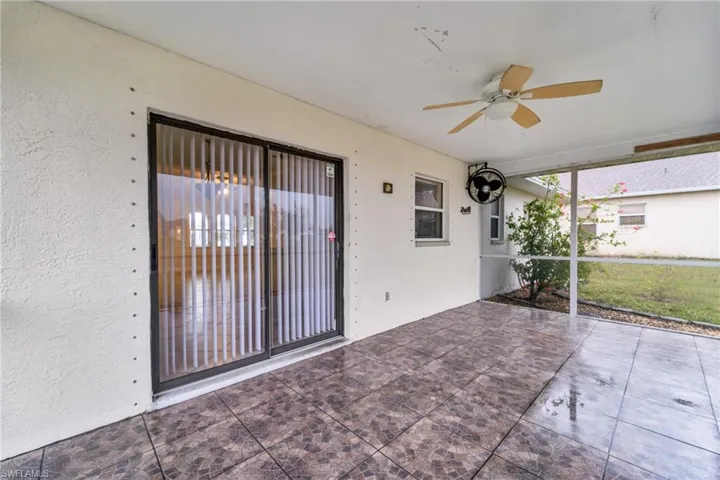 View of patio featuring a sunroom and a ceiling fan
