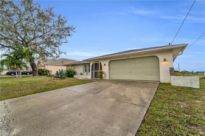 Single story home with a front lawn, stucco siding, concrete driveway, and an attached garage
