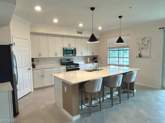 Kitchen has breakfast bar w/quartz countertops.